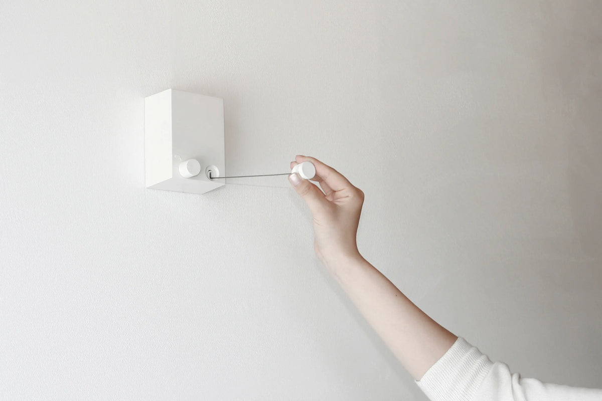 Hand pulling the retractable indoor clothesline